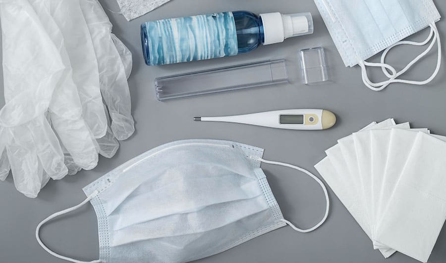 Photo of medical equipment, including mask, thermometer, and gloves.