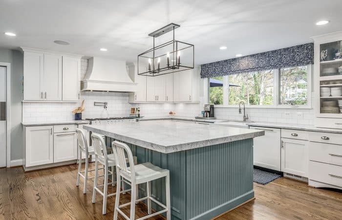 A bright kitchen with gray-blue cabinets and gray countertops