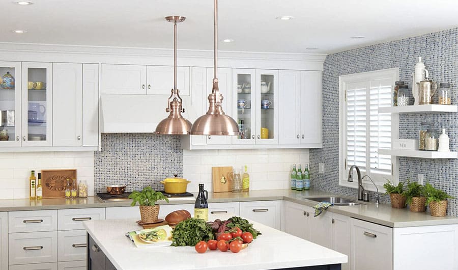 A kitchen with tiled walls and metal light fixtures