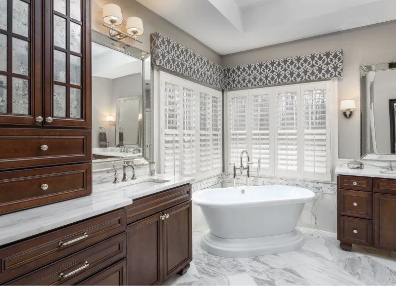 Rendon Remodeling master bath renovation with dark wood vanities and soaking tub